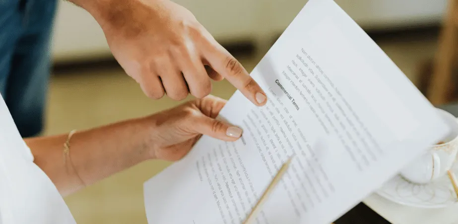 Pessoas analisando um relatório impresso, apontando para o texto